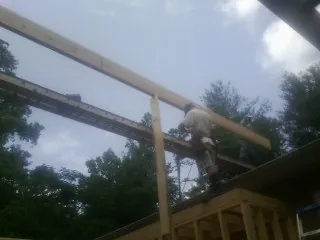 Carpenter setting a ridge beam over a new addition frame — Ice Dam Removal by Roofing Brothers in Brea