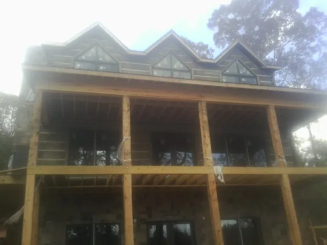 Dormers and porch framing on a large log home under construction — Roof Coating work by our crew in Brea